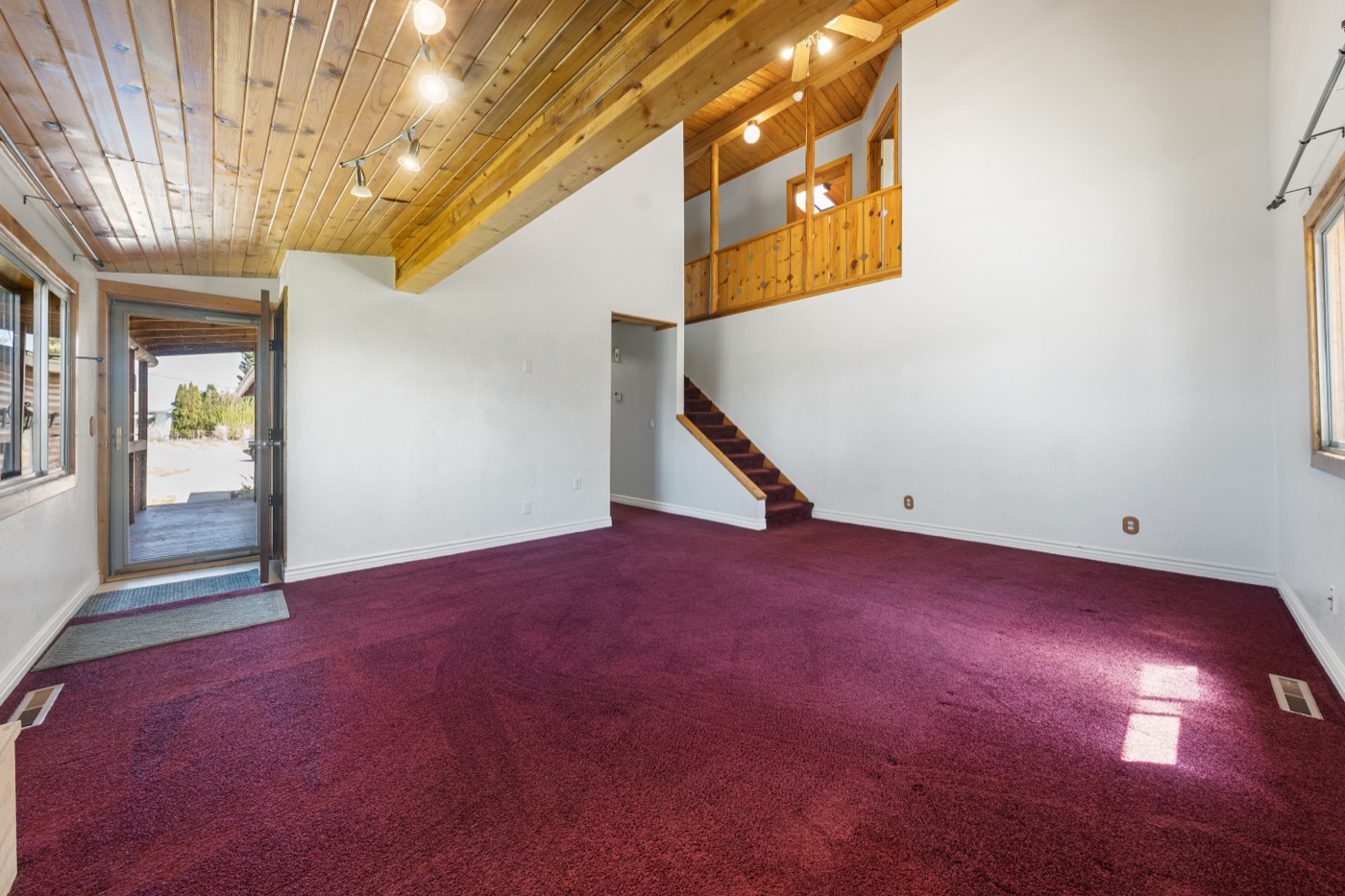 Living room with French door access and full vaulted ceiling