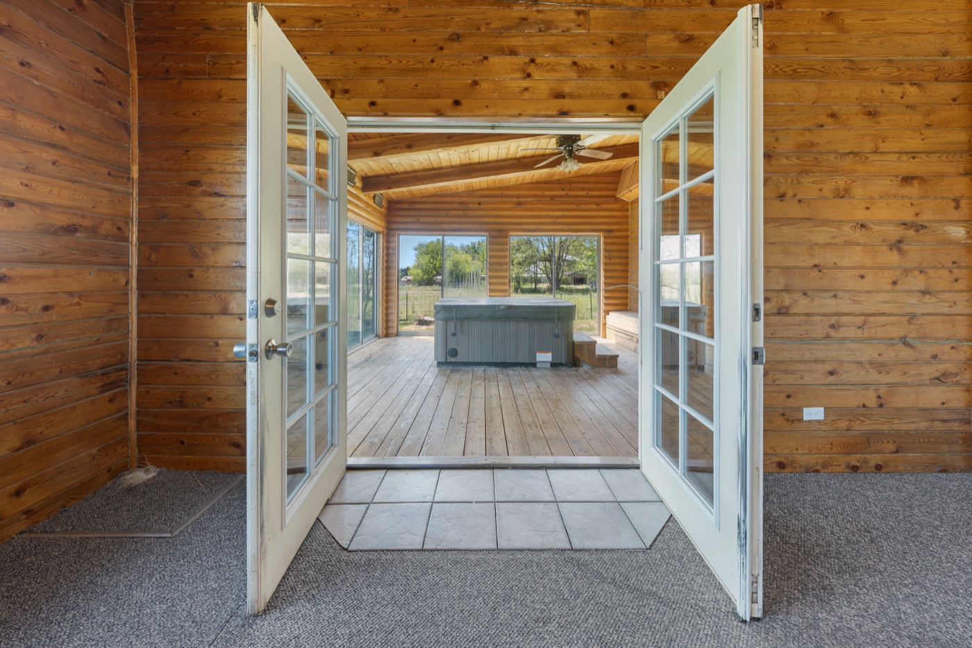 French doors opening into the enclosed sunroom and hot tub