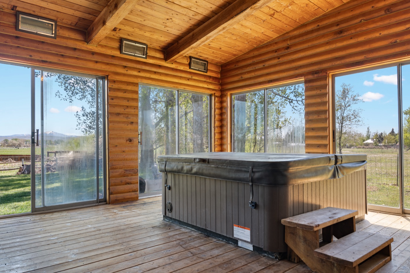 Sunroom interior with hot tub and wraparound windows